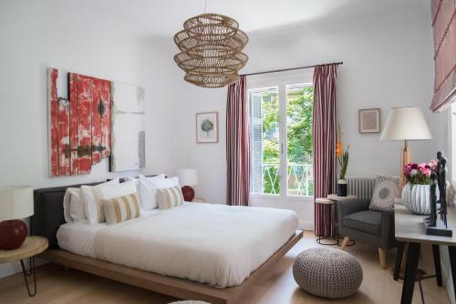 a bedroom with a large white bed and a window at Virtue by Stylish Stays in Athens