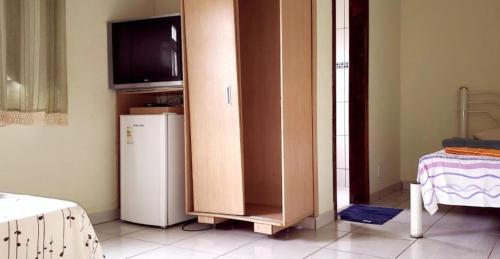 Pokój z szafką z telewizorem i lodówką w obiekcie Hotel Real de Caeté w mieście Caeté
