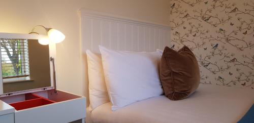 a bedroom with a bed with a pillow on it at Three Ways House Hotel in Chipping Campden