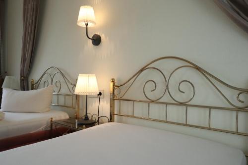 a bedroom with two beds and two lamps at Schwarzwaldhotel Stollen in Gutach im Breisgau