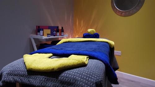 a bedroom with a bed with a blue and yellow blanket at LLety Cynin in Llangynin