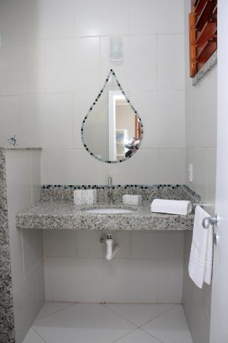 a bathroom with a sink and a mirror at Pousada da Luz in Aquiraz
