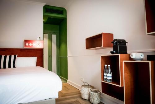 a bedroom with a bed and a green accent wall at Fitz Roy Urban Hotel, Bar and Garden in Maastricht