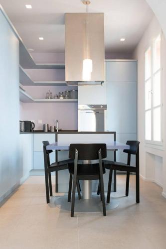 une salle à manger avec une table et des chaises dans une cuisine dans l'établissement Pure & chic 2beds/2baths in centre!, à Cannes