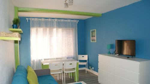a living room with blue walls and a table and a tv at Résidence Consuegra in Pas de la Casa