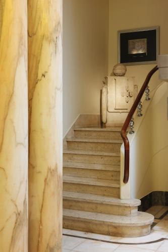 a staircase in a building with a statue on the wall at Hotel Britania Art Deco - Lisbon Heritage Collection - Avenida in Lisbon