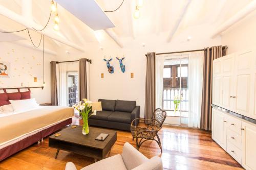 a bedroom with a bed and a couch and a table at X.O Art House in Cusco