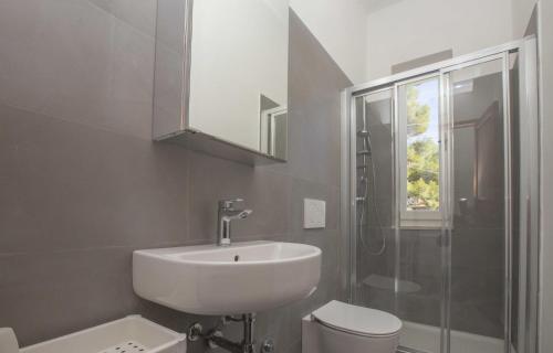 a bathroom with a sink and a toilet and a shower at Casa Bianca - Goelba in Pomonte