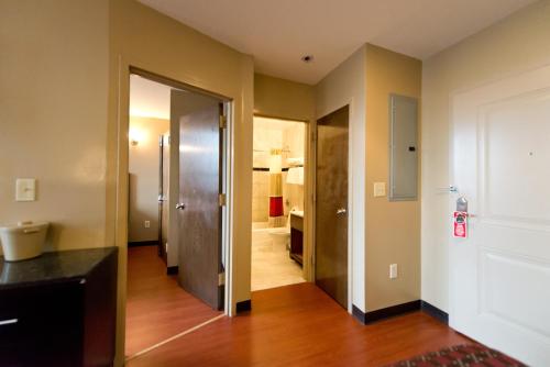 an empty room with a door leading to a bathroom at Dynasty Hotel and Suites New York LaGuardia Hotel in Queens