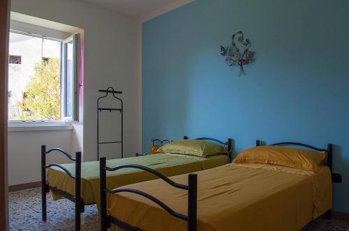 two beds in a room with blue walls at Bed &Breakfast Bellavista in San Giovanni Bianco