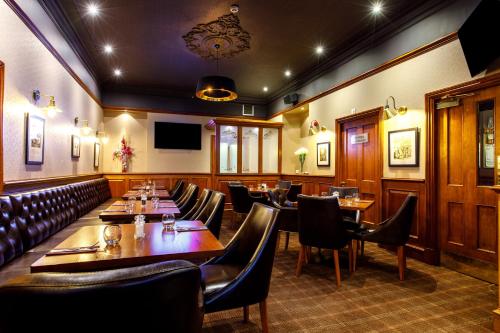 a restaurant with wooden tables and leather chairs at Ferryhill House Hotel in Aberdeen
