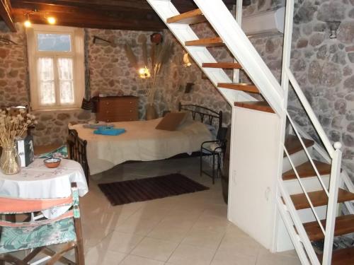 a room with a table and a staircase in a building at Au pied de la falaise rouge in Leonidion