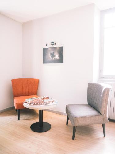 a living room with two chairs and a table at Hôtel de la Rhune in Ascain