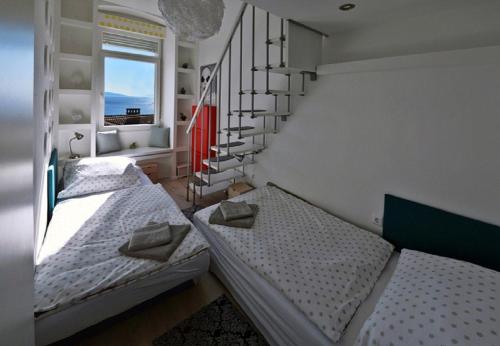two twin beds in a room with a staircase at Aurora Apartment in Rijeka