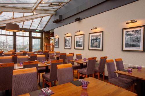 a dining room with wooden tables and chairs at Ferryhill House Hotel in Aberdeen