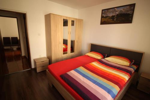 a bedroom with a bed with a colorful striped blanket at Orion in Predeal