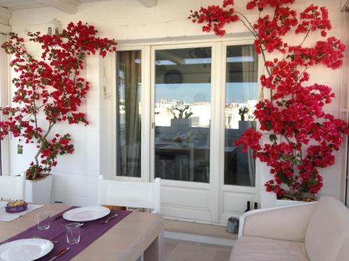 a dining room with red flowers and a table at B&B Donnapasqua in Polignano a Mare