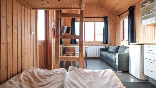 a living room with a bed and a couch at Hvammstangi Cottages in Hvammstangi