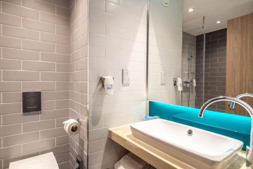 a white bathroom with a sink and a shower at Holiday Inn Express - London Heathrow T4 by IHG in Hillingdon