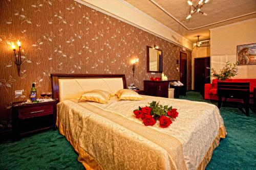 a bedroom with a bed with red roses on it at Achillion Palace in Kalambaki