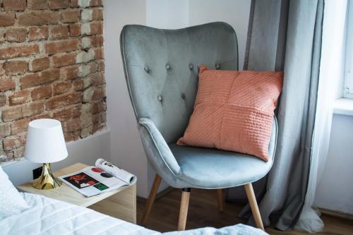 a blue chair with a pillow on it next to a bed at LION apartments - SILVER in Kraków