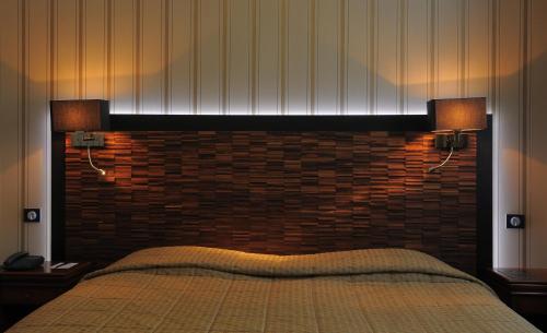 a bedroom with a bed with a brick wall at Le Grand Hotel in Tours