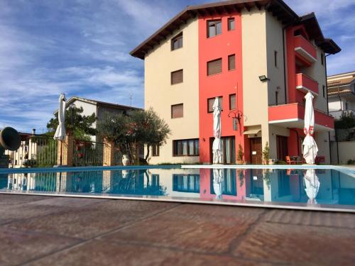 a hotel with a swimming pool in front of a building at Hotel Opera' in Moscufo