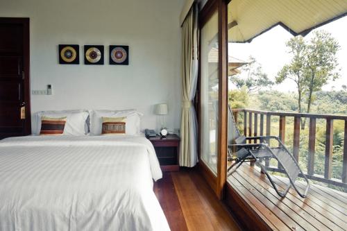a bedroom with a bed and a balcony at Sabaidee Valley in Ban Gnik