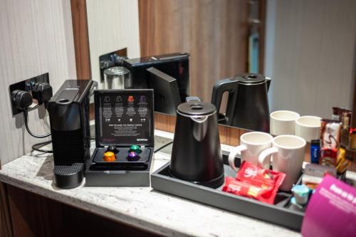 a counter with two coffee makers and cups on it at Crowne Plaza London Heathrow T4 by IHG in Hillingdon