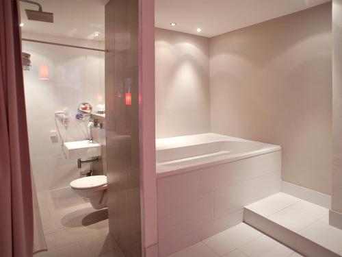 a bathroom with a shower, toilet, sink and tub at Hotel PurPur in Prague