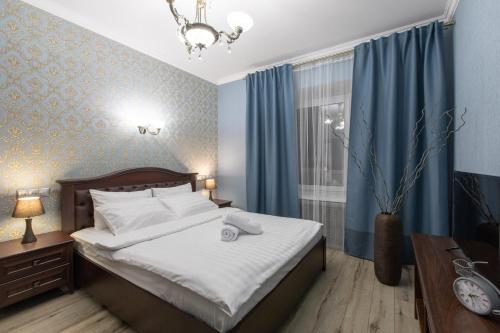 モスクワにあるFortNight 4 near Radisson-2 roomsのベッドルーム1室(ベッド1台、青いカーテン付きの窓付)