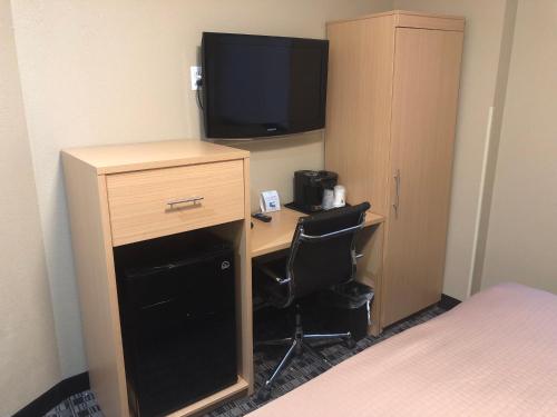 a room with a desk with a television and a bed at Days Inn by Wyndham Brooklyn Borough Park in Brooklyn