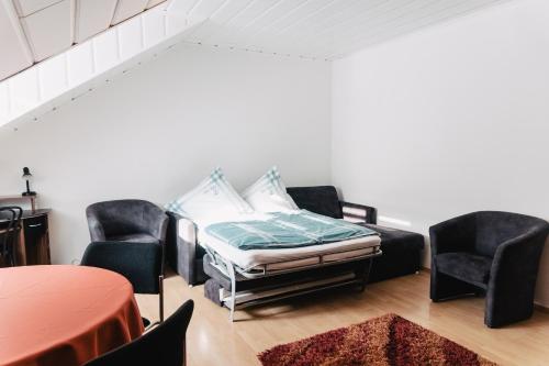a room with a bed and two chairs and a table at Apartment in Innenstadtnähe in Darmstadt