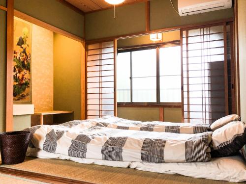 um quarto com uma cama grande em frente a uma janela em A Leaf Inn em Quioto