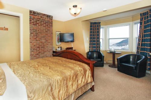 a hotel room with a bed and a tv at Abba Inn Guest House in St. John's