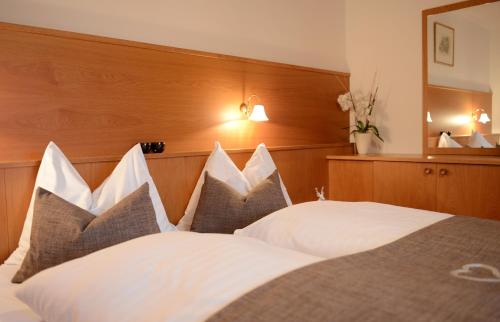 a bedroom with a large bed with white pillows at Miraval Perathoner Andreas in Ortisei