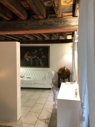 a living room with a white couch and a painting at Domus Antiqua San Lorenzo in Genova