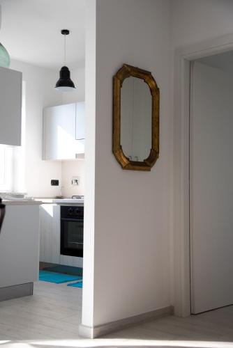 a white kitchen with a mirror on the wall at La Strelitzia Cervo Mare in Cervo