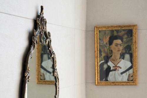 a mirror hanging on a wall next to a painting at La Strelitzia Cervo Mare in Cervo