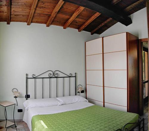 - une chambre avec un lit et une couverture verte dans l'établissement Residence Albornoz, à Piediluco