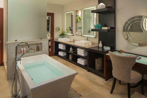 a bathroom with a tub and a sink and a mirror at Sandals Halcyon Beach All Inclusive - Couples Only in Vigie