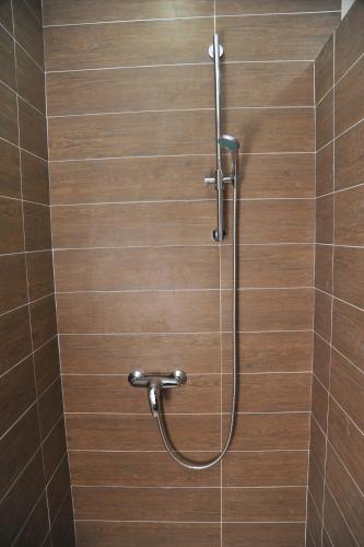 a shower with a hose in a tiled bathroom at MISS Premier 19 Milmari in Kopaonik