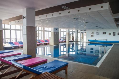 a large swimming pool with tables and chairs in a building at MISS Premier 19 Milmari in Kopaonik