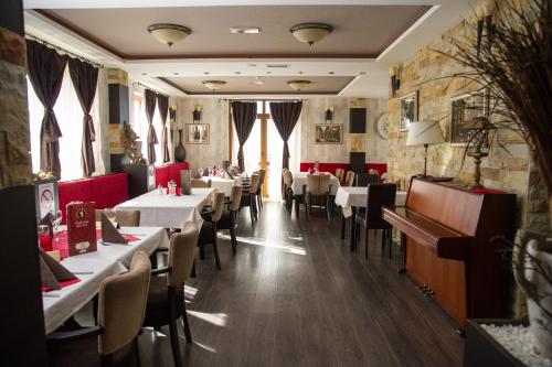a restaurant with tables and chairs in a room at MISS Premier 19 Milmari in Kopaonik
