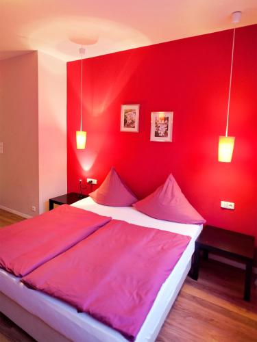 a red bedroom with a large bed with red walls at Hotel PurPur in Prague