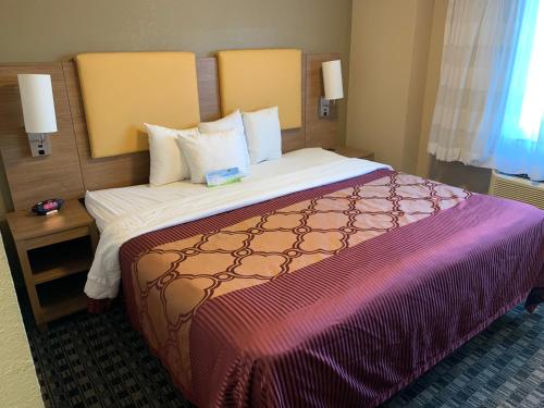 a hotel room with a large bed with a purple blanket at Days Inn by Wyndham Brooklyn Borough Park in Brooklyn