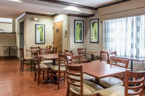 een eetkamer met houten tafels en stoelen bij Baymont by Wyndham Flat Rock in Flat Rock