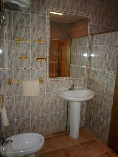 a bathroom with a sink and a toilet and a mirror at Casas Cueva Paloma in Los Carriones