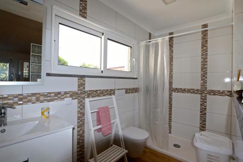 ヴィラモウラにあるVilla Caroline 3 - Clever Detailsのバスルーム(トイレ、洗面台付)、窓が備わります。