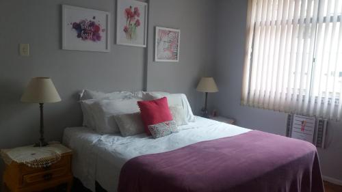 1 dormitorio con 1 cama con manta morada en Apartamento 2Quartos PraiaMetro Copacabana, en Río de Janeiro